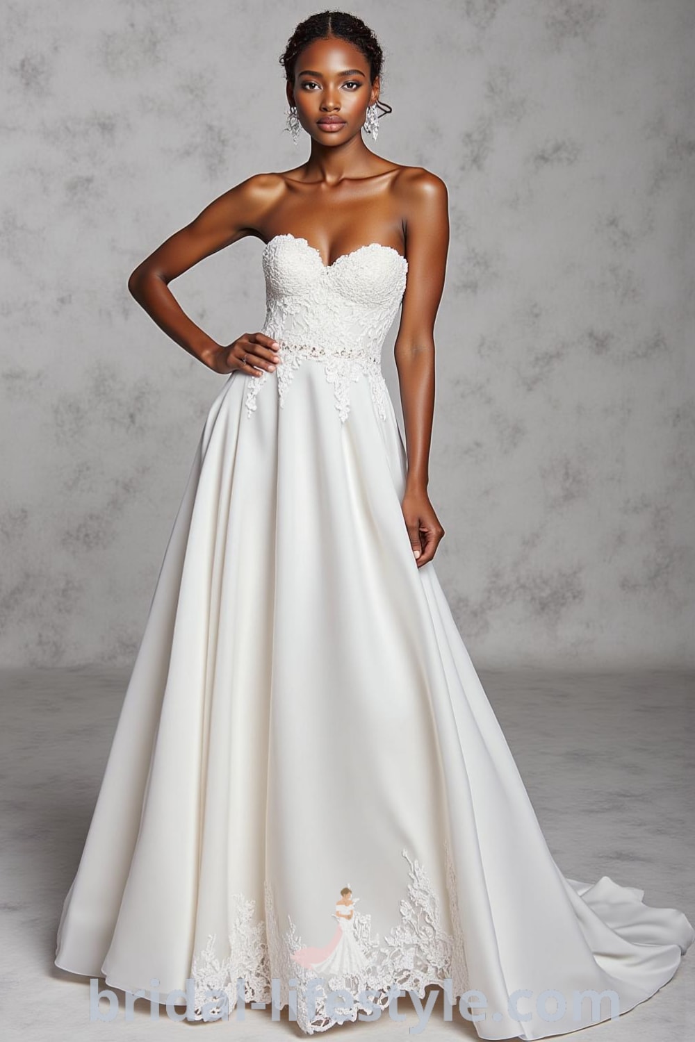 Strapless A-line wedding dress with lace appliqués, flowing satin skirt, and delicate embroidery along the hem, featuring a sweetheart neckline. bridal-lifestyle.com