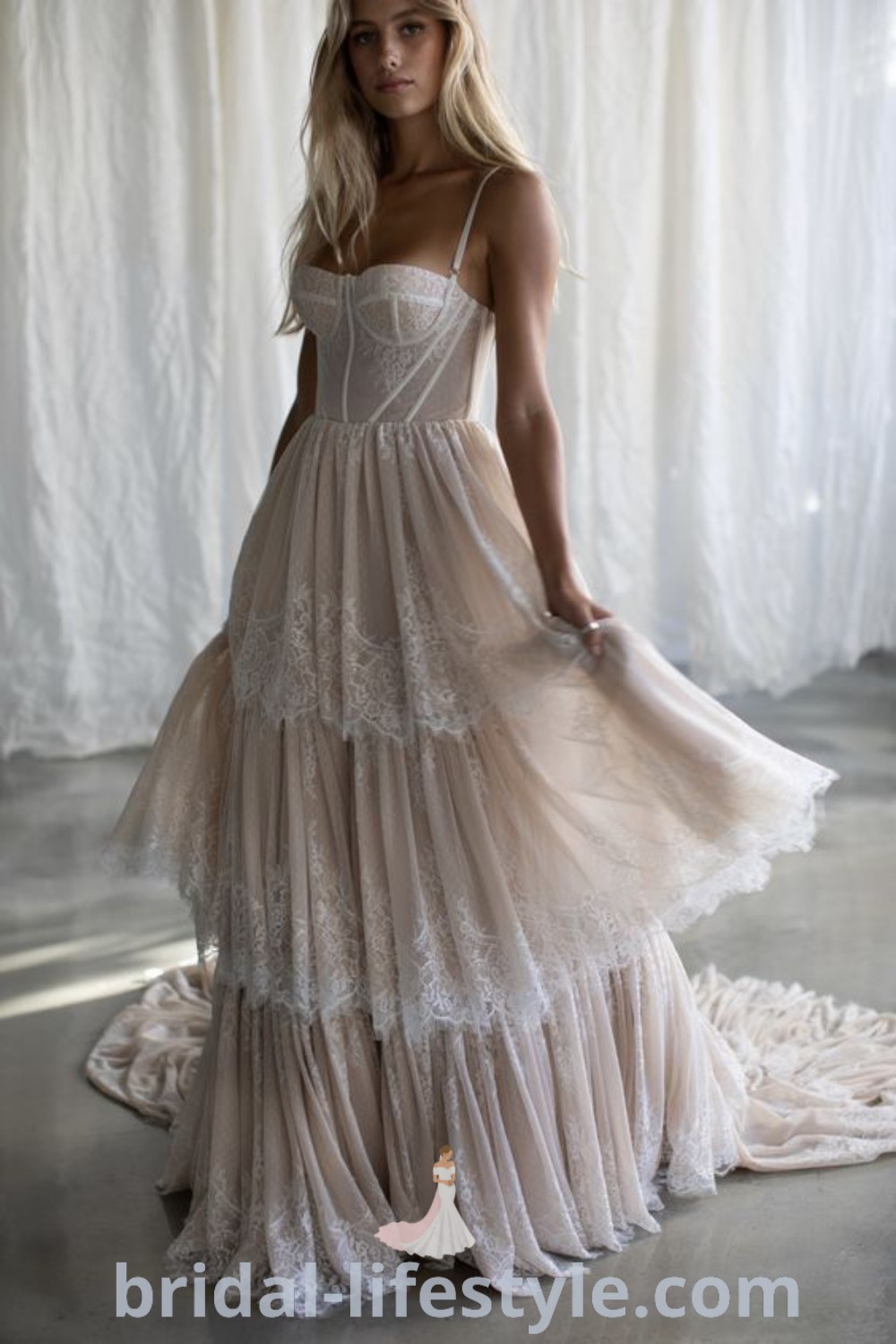 A woman in a Bohemian Lace Wedding Dress standing on a rug, showcasing an elegant tiered design that reflects the latest bridal trends. This romantic dress is perfect for dreamy brides seeking the best aesthetic ideas for their special day. Explore more inspiration at bridal-lifestyle.com.