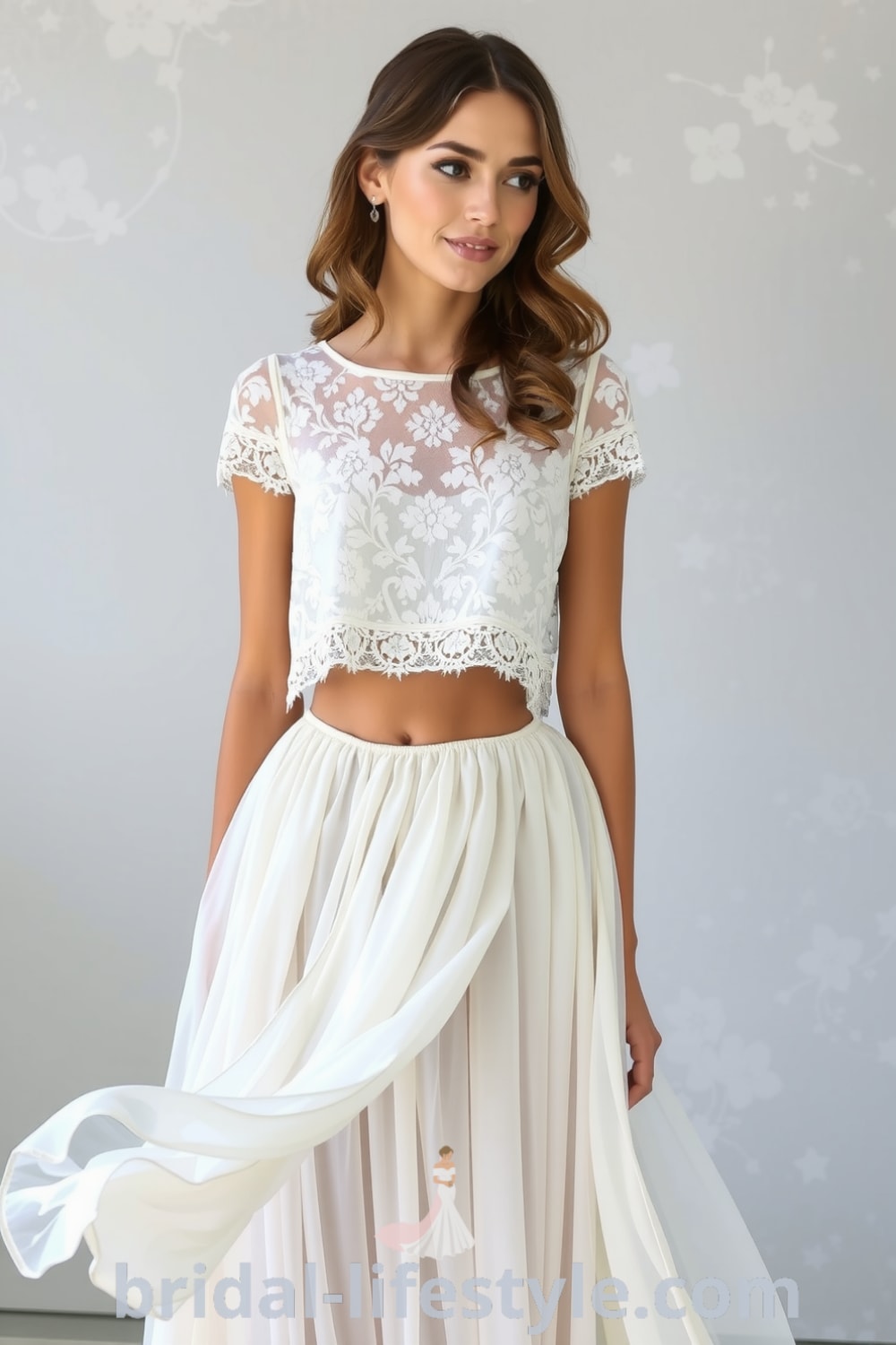 A two-piece bohemian wedding dress with a lace crop top featuring floral patterns and a flowing chiffon skirt, ideal for outdoor ceremonies. bridal-lifestyle.com