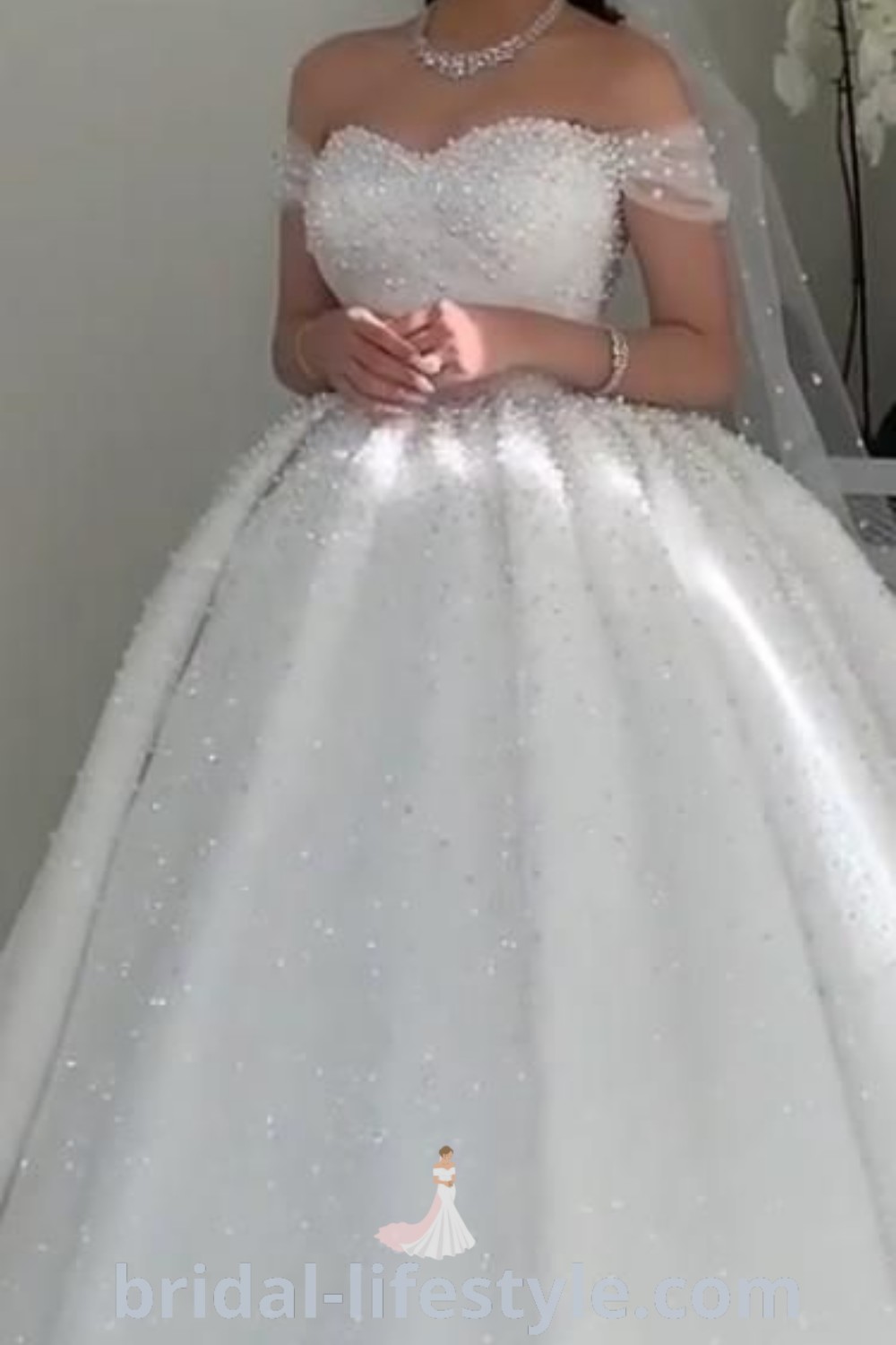 An elegant off the shoulder wedding dress in a princess ballgown style, featuring sparkling details for a dreamy bridal look. Perfect for brides seeking the latest trends and unique aesthetic ideas for their special day. For inspirational wedding dress styles, visit bridal-lifestyle.com.