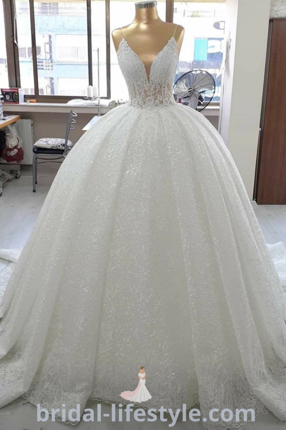 An elegant white wedding dress showcased in a beautifully decorated room with ample furniture and large windows, highlighting bridal trends and aesthetic ideas from bridal-lifestyle.com. Perfect for brides seeking beautiful bridal dresses or wedding dress inspiration for their special day.