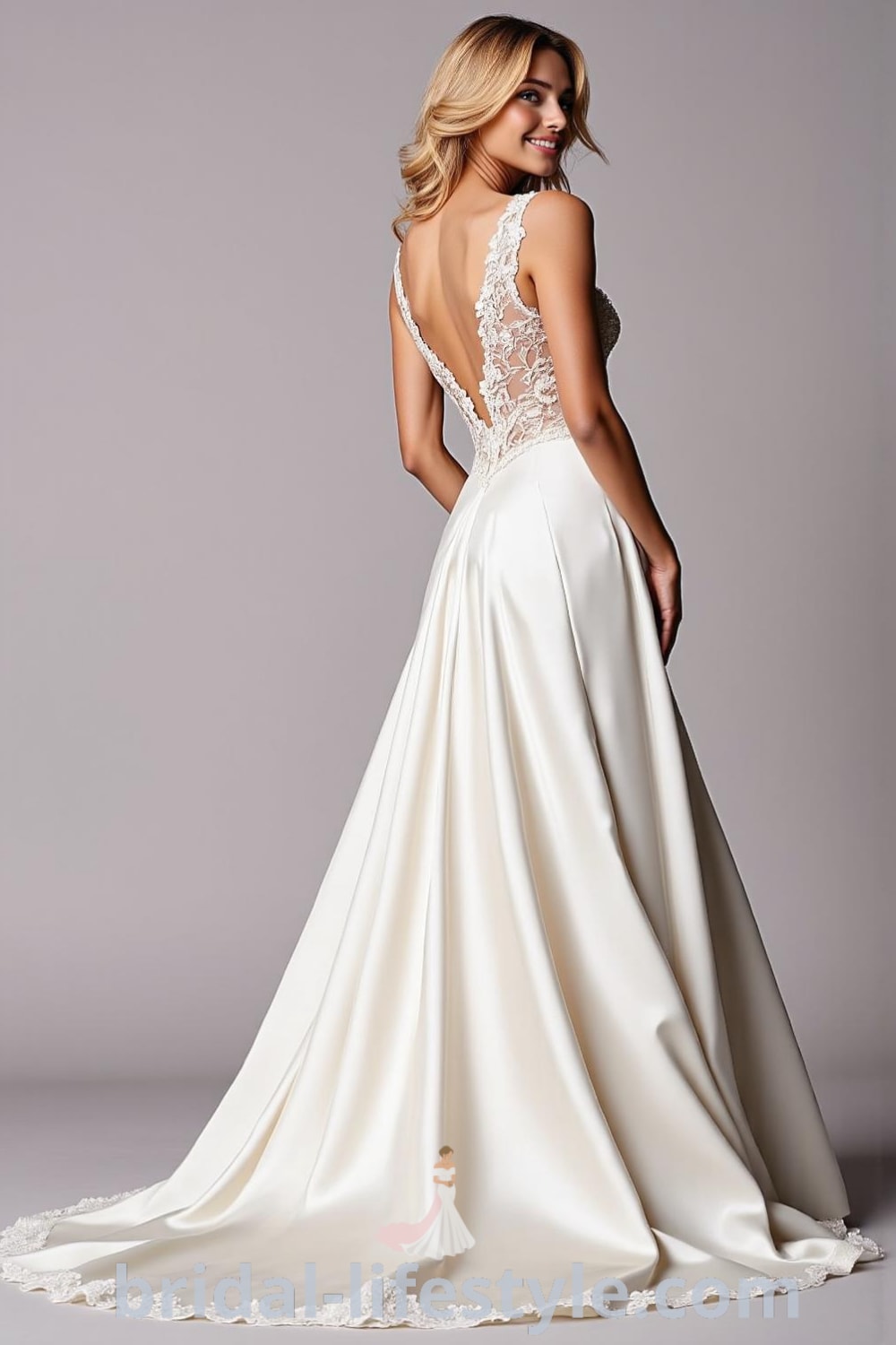 Elegant A-line satin wedding dress with a structured bodice, flowing skirt, lace appliqués, and an open back. bridal-lifestyle.com