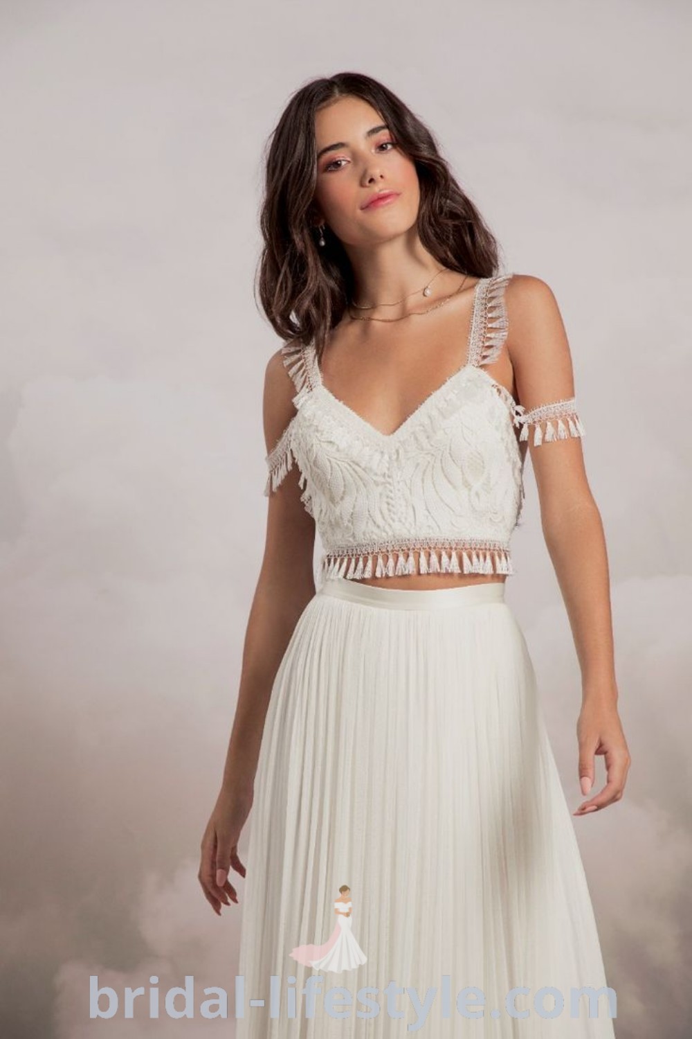 A woman in an elegant white dress, posing confidently with her hands on her hips, embodying the spirit of spiritual fashion and bridal trends. This style offers inspiration for summer weddings and captures the essence of dreamy celebrations. Discover more aesthetic ideas at bridal-lifestyle.com.