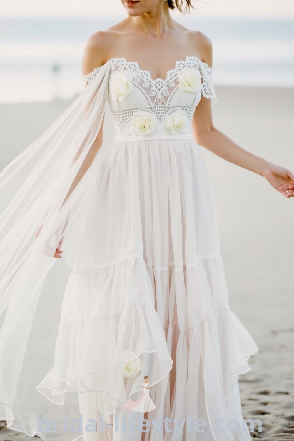 Boho beach wedding dress with flowing layers of lace, off-the-shoulder neckline, tiered skirt, crochet details, and floral appliqués. bridal-lifestyle.com
