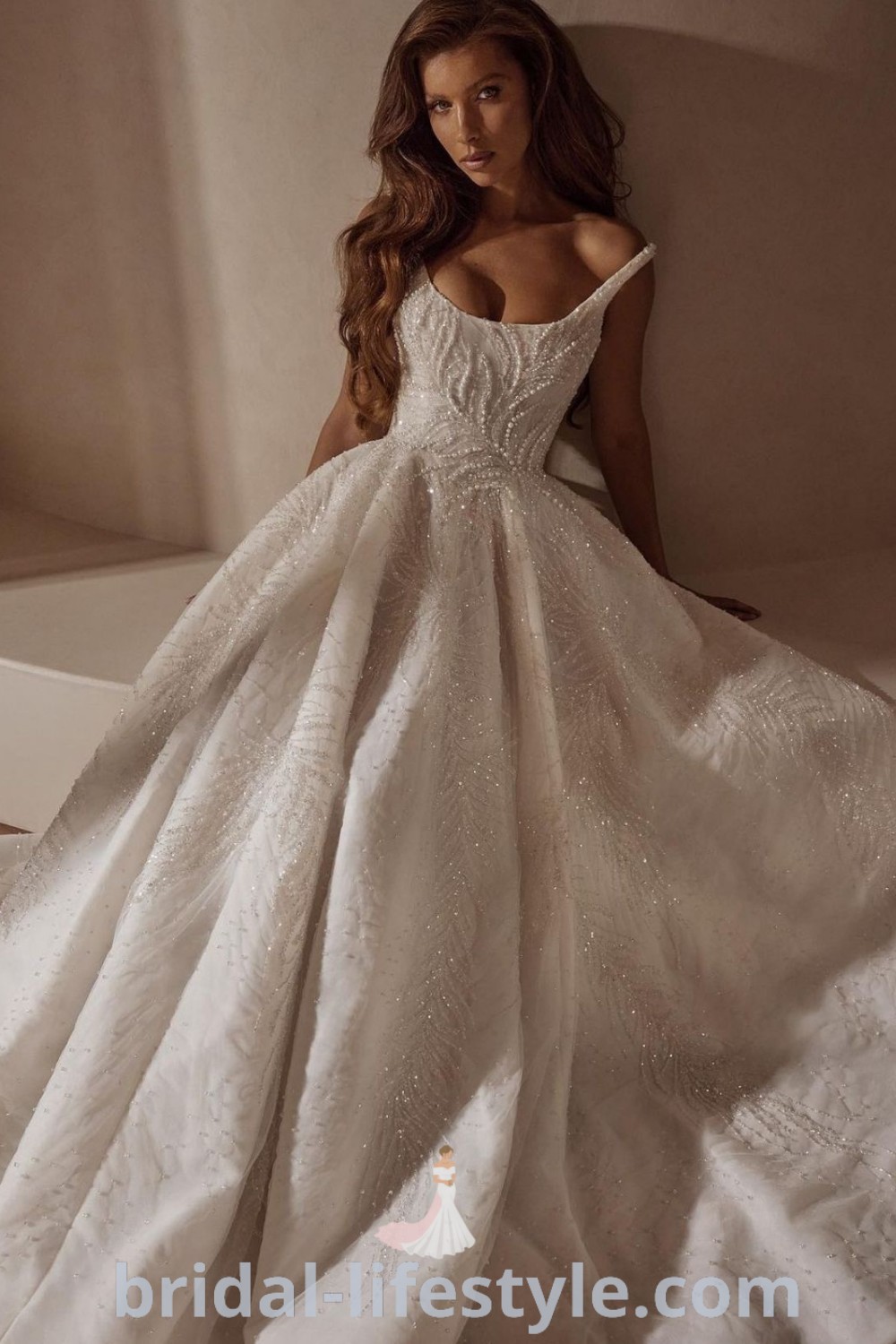 An elegant woman in a big silk wedding dress with a square neckline sitting on the floor, showcasing a dreamy vintage Italian and Cinderella-inspired design. Discover elegant wedding dresses with Swarovski details for every bride