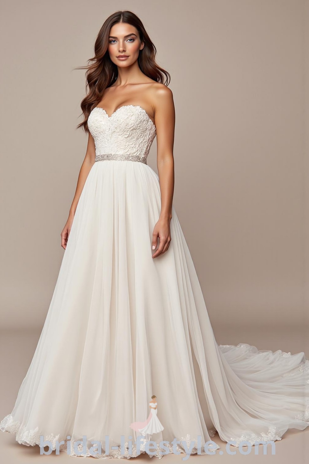 A-line strapless wedding dress with fitted bodice, cascading tulle skirt, intricate lace appliqués at the neckline, and a charming sweep train. bridal-lifestyle.com