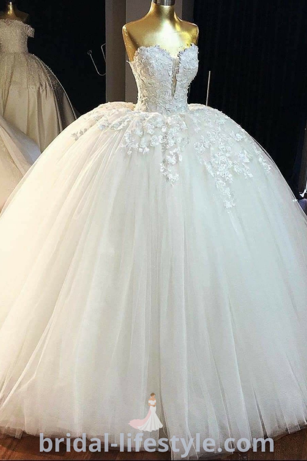 A white ball gown with flowers on the skirt and bustle, perfectly displayed for brides seeking elegant wedding dresses, Sweet 16 dresses, and quinceanera styles. This poofy dress complements romantic themes and offers inspiration for special occasions. Discover more at bridal-lifestyle.com.