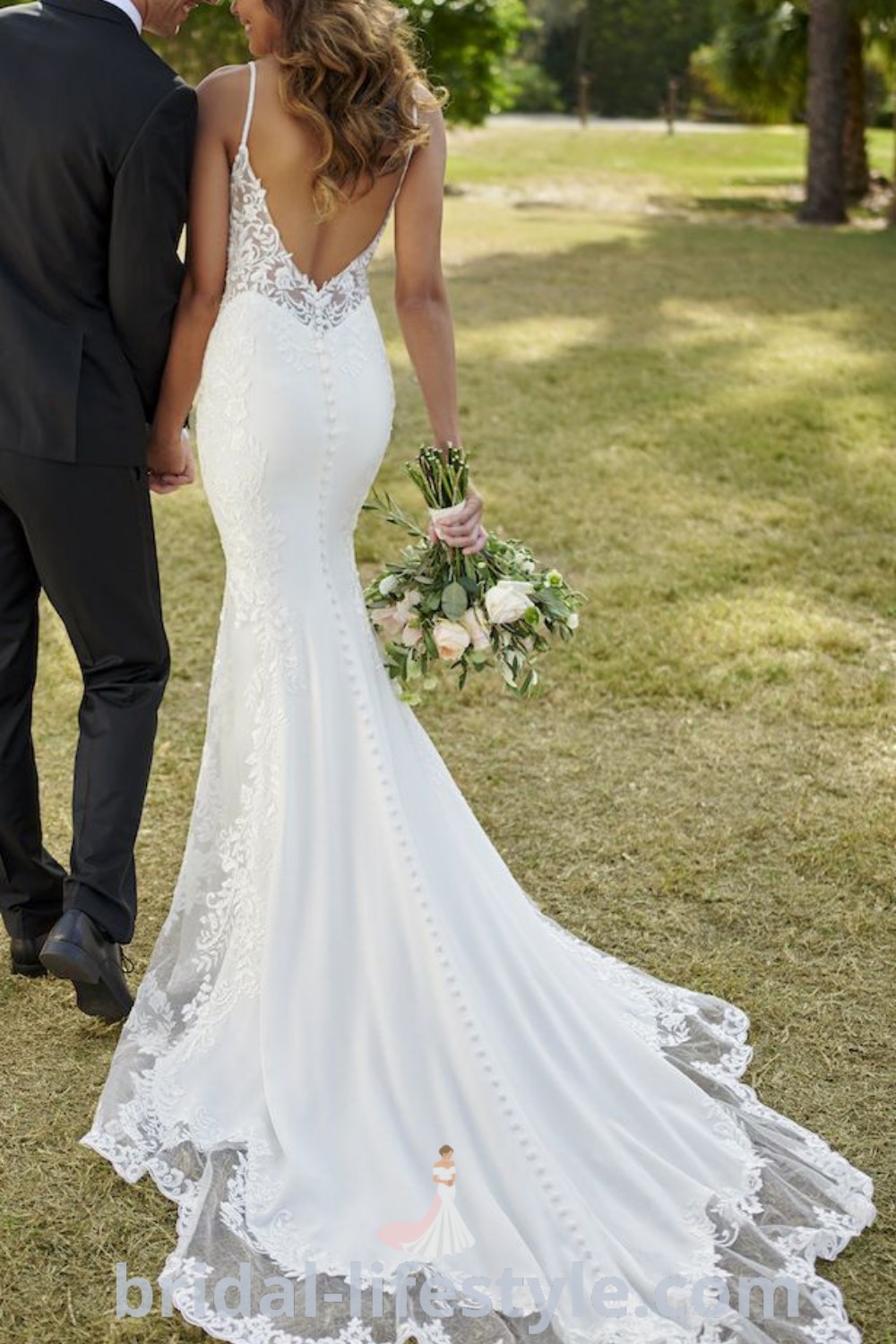 A romantic scene of a bride and groom standing in the grass, showcasing a stunning mermaid wedding dress with lace by Stella York. This image captures the elegance and best aesthetic ideas for the special day, featured on bridal-lifestyle.com.