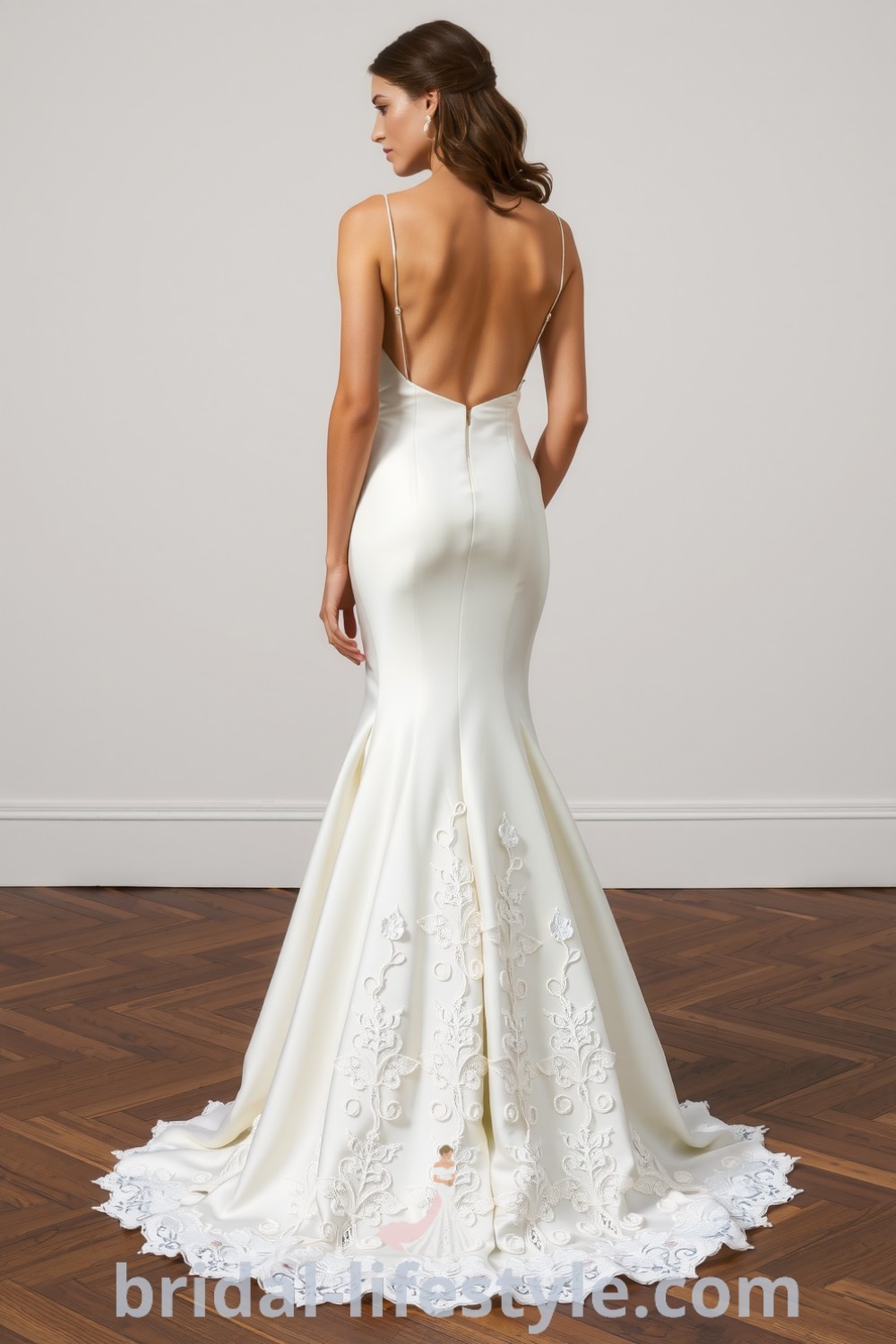 Fit and flare wedding dress in soft satin with open back and intricate lace appliqués, blending classic and contemporary styles. bridal-lifestyle.com