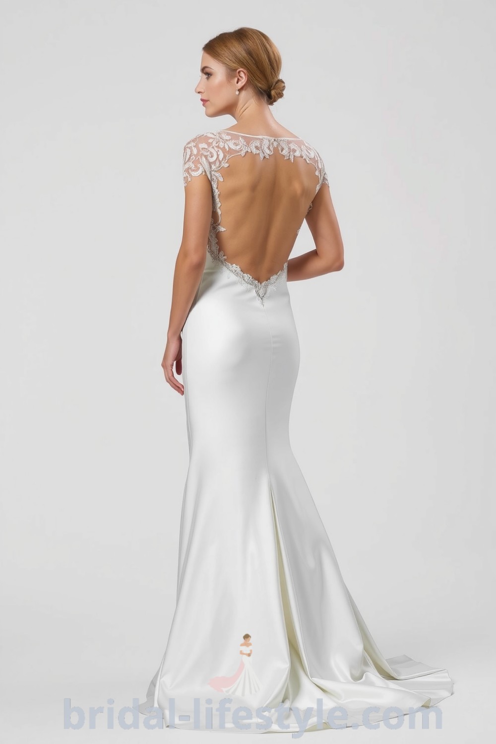 Fit and flare wedding dress made of soft satin with an open back adorned with delicate lace detailing, featuring graceful drape and mermaid-inspired flares. bridal-lifestyle.com