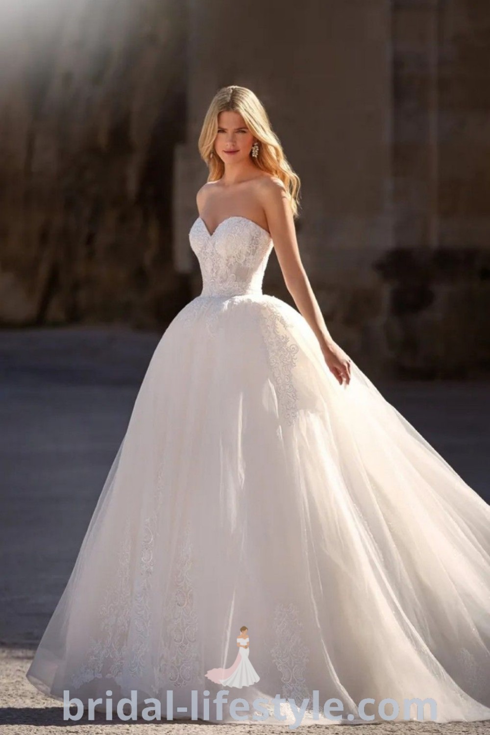 A woman in a white regal wedding dress with a strapless design and elegant mermaid skirt, posing confidently for the camera. This classy gown is perfect for brides seeking the best aesthetic ideas for their special day. Explore more inspiration and trends at bridal-lifestyle.com.