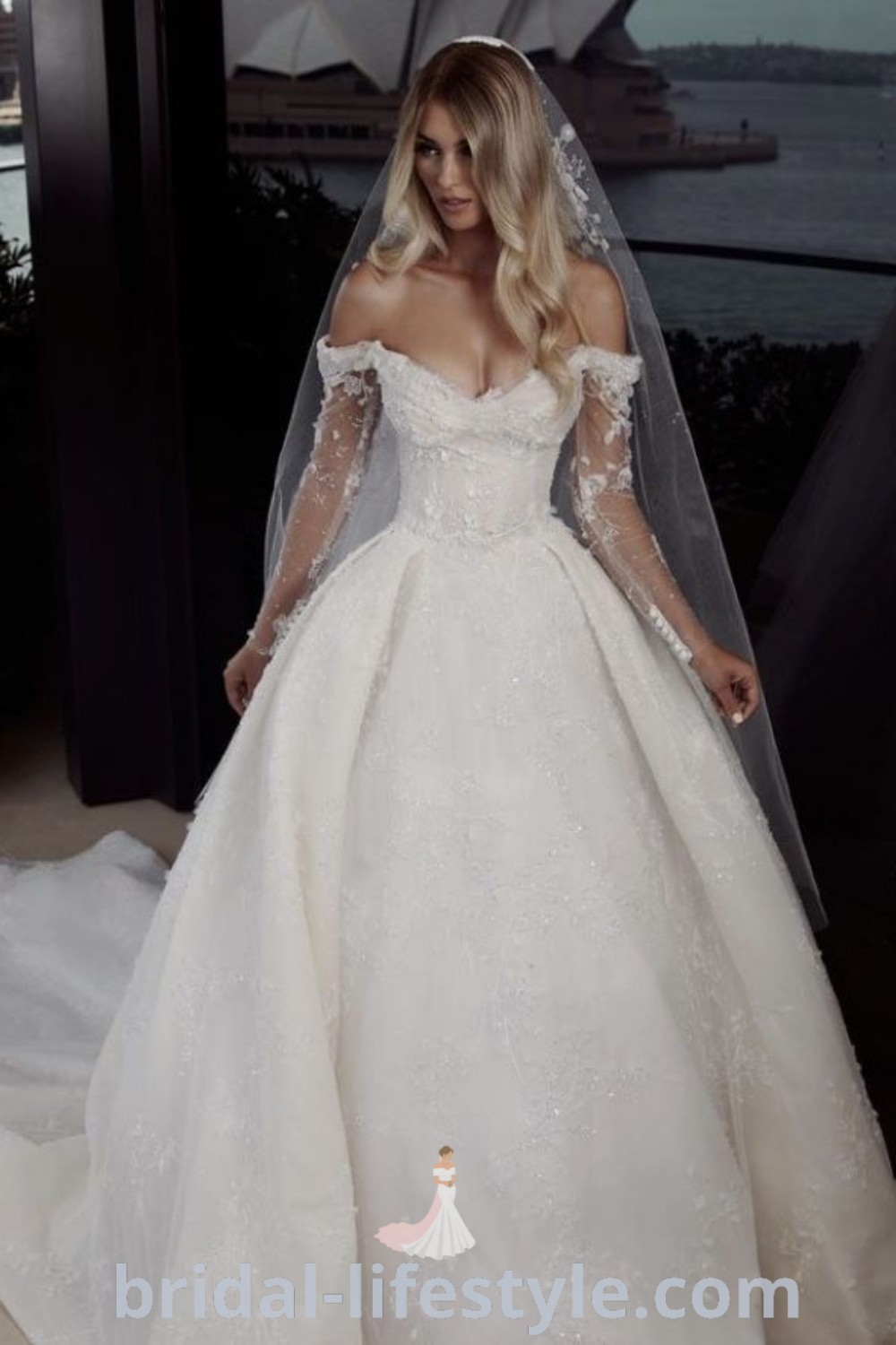 An elegant off the shoulder ballgown wedding dress featuring long sleeves and lace details for romantic brides. This stunning gown represents the best in wedding dress trends, perfect for creating a dreamy wedding aesthetic. Discover more at bridal-lifestyle.com.