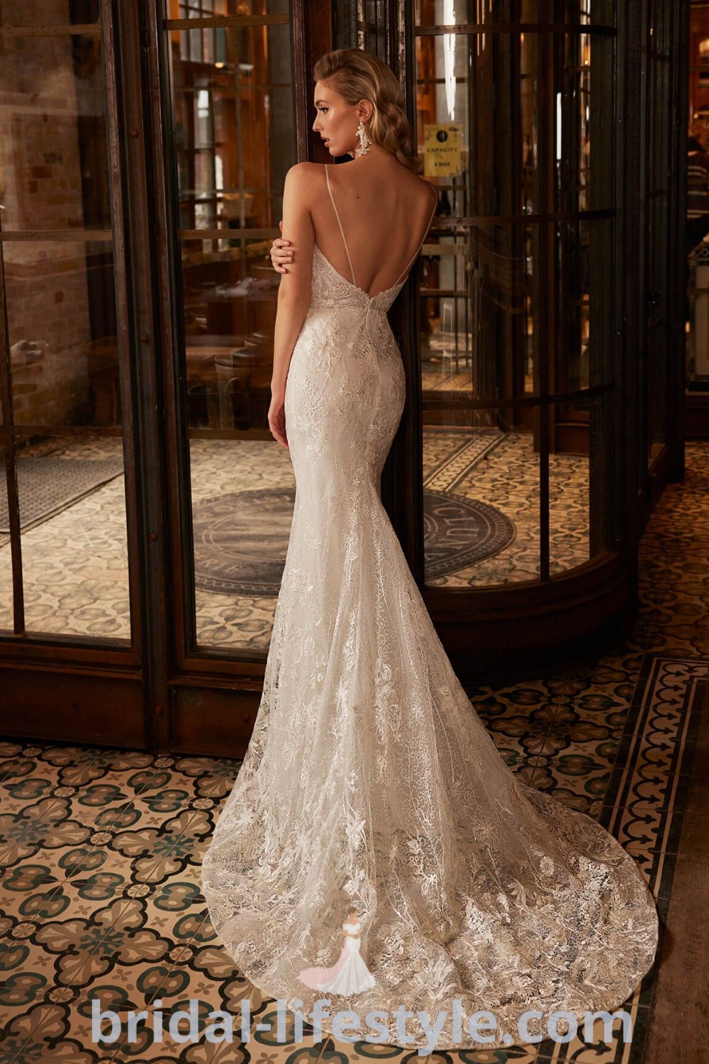 An elegant dainty lace wedding dress featuring a tight fit and open back, perfect for brides seeking aesthetic inspiration. This style encompasses the best wedding dress trends for dreamy brides and highlights the romantic elements ideal for the special day. Discover more at bridal-lifestyle.com.