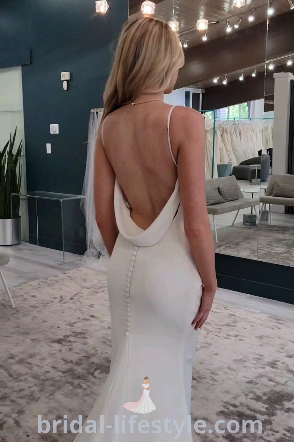 An elegant satin mermaid wedding dress with sleeves and an open back, featuring sleek buttons and a low back design that offers a modern touch. Perfect for dreamy brides, this gown combines trendy aesthetics with timeless romance, providing ideas for the special day at bridal-lifestyle.com.