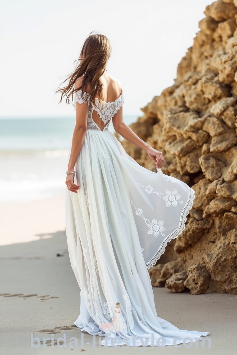 Boho beach wedding dress in lightweight linen and chiffon with off-the-shoulder design and lace appliqués, flowing skirt cascading to the sand. bridal-lifestyle.com