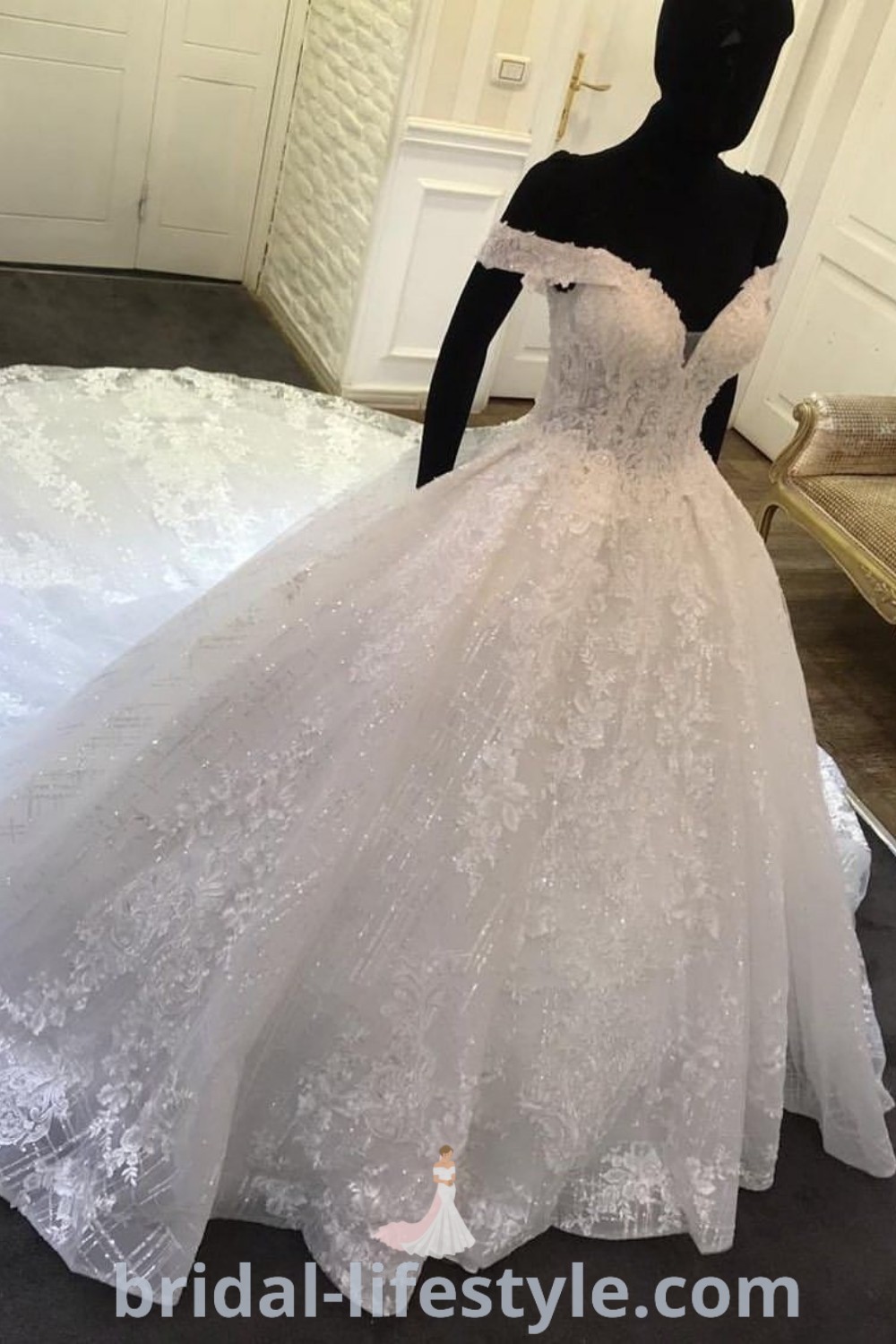 A mannequin showcases a beautiful white wedding dress with off the shoulder sleeves, representing the latest trends in big puffy wedding dresses. Ideal for every bride