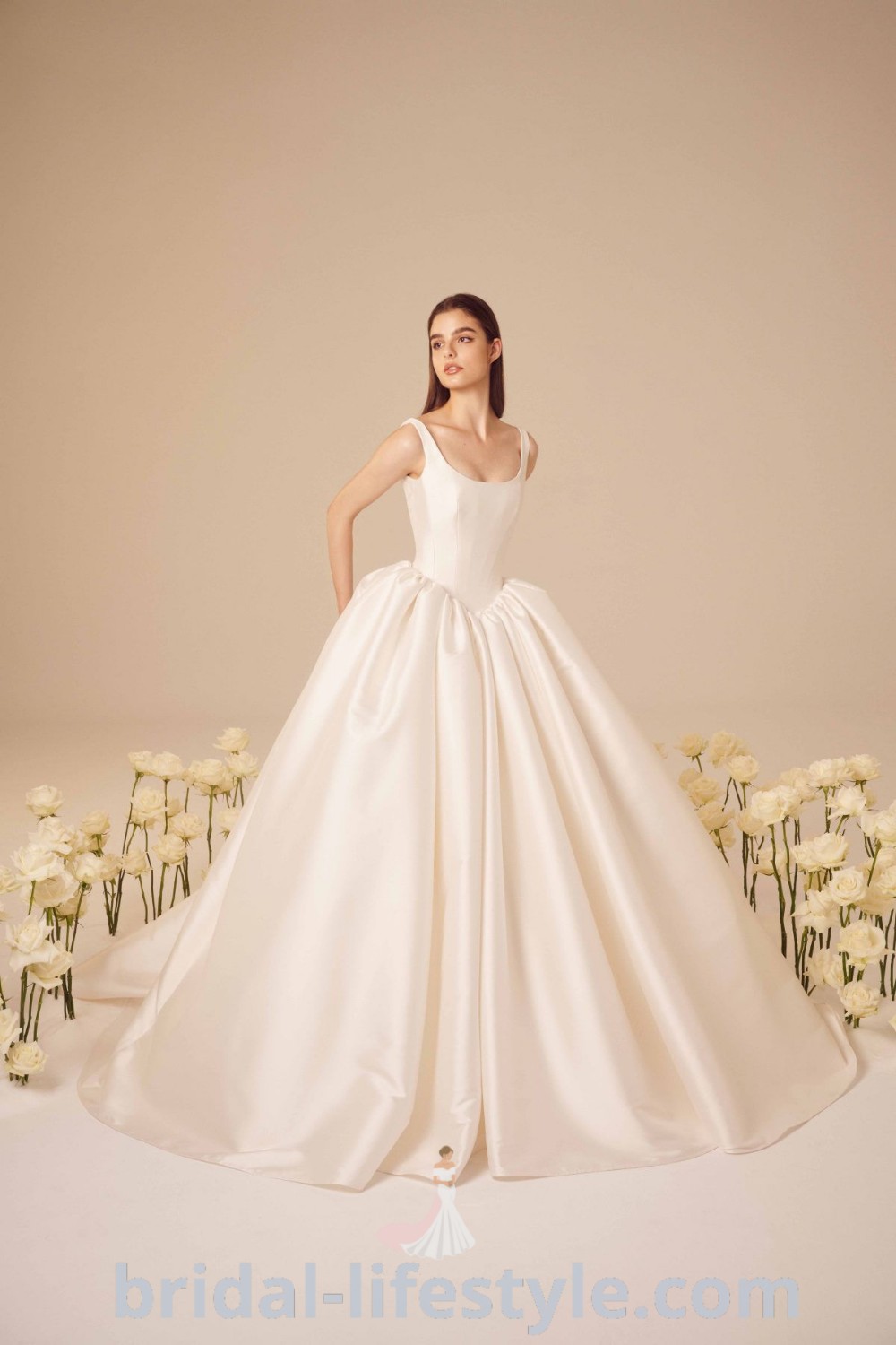 An elegant woman in a white off-the-shoulder corset wedding dress surrounded by flowers, embodying bridal beauty. Discover inspiring wedding dress trends like long sleeve structured gowns and classy ballgowns that fit every bride