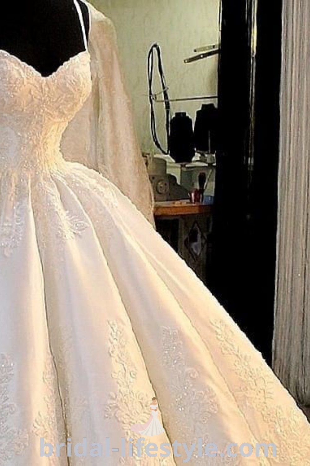 An elegant poofy wedding dress displayed in front of a mannequin