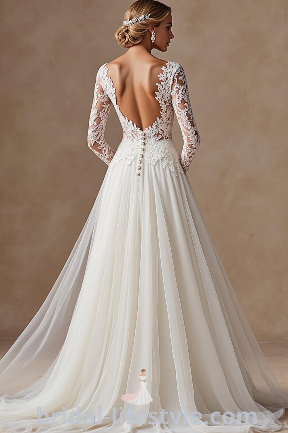A-line wedding dress with long lace sleeves, fitted bodice, flowing tulle skirt, soft rounded neckline, and delicate buttons at the back. bridal-lifestyle.com
