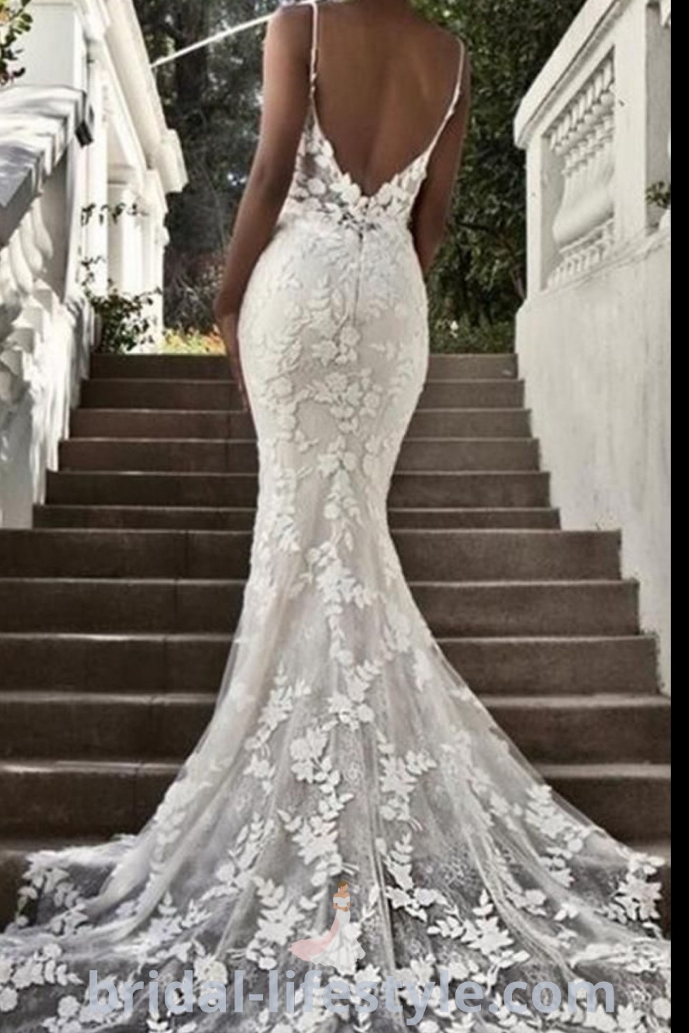 An elegant slim fit wedding dress with an open back and floral appliques, perfect for brides seeking a romantic and chic look. Discover the best wedding trends and inspiration for dresses of your dreams at bridal-lifestyle.com.