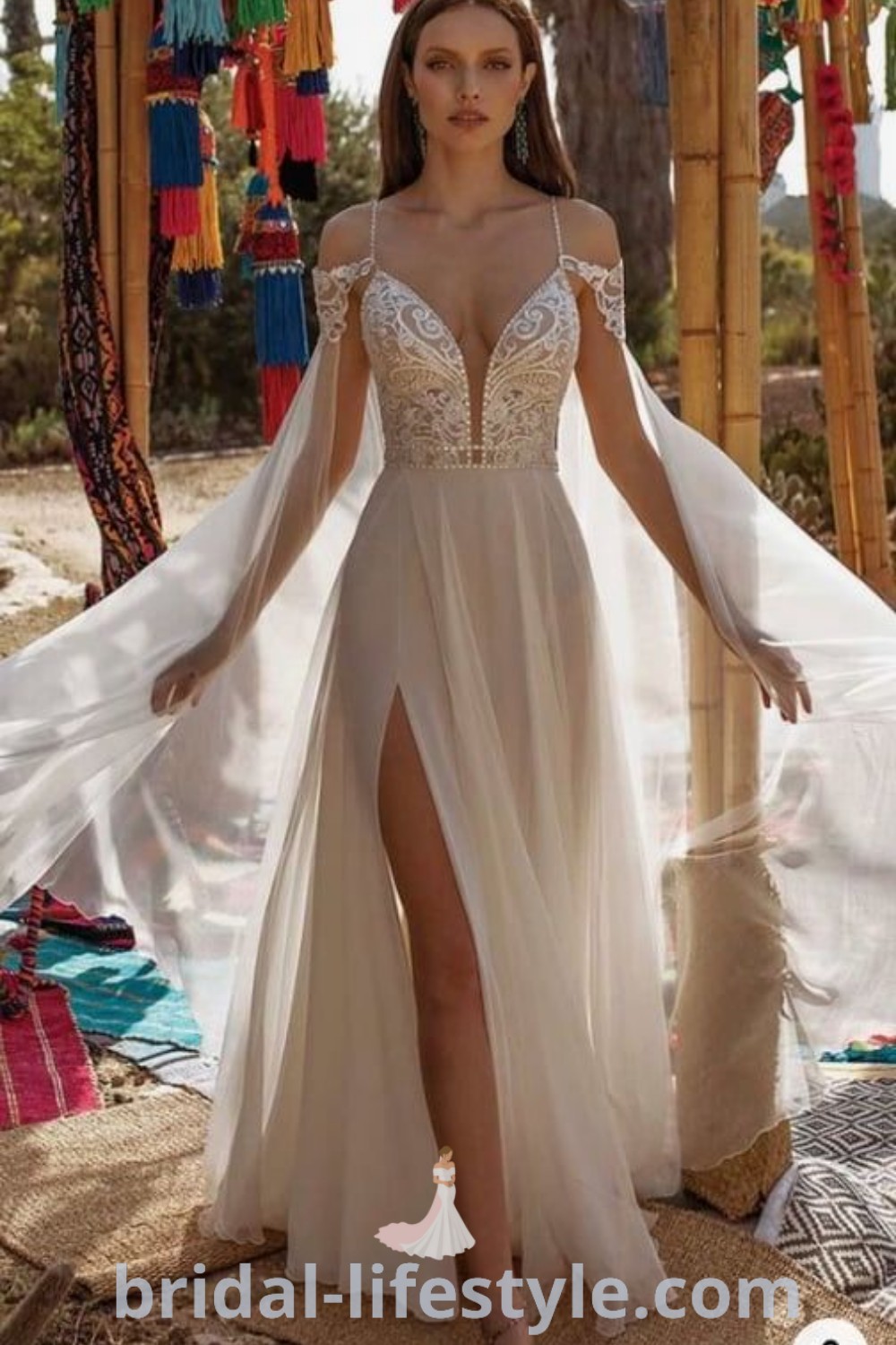 A woman in a white dress standing on the ground, showcasing a beachy wedding dress complemented by a wedding cape veil. This elegant style is perfect for dreamy brides seeking inspiration and ideas for their special day. Discover the best trends and aesthetic ideas at bridal-lifestyle.com.