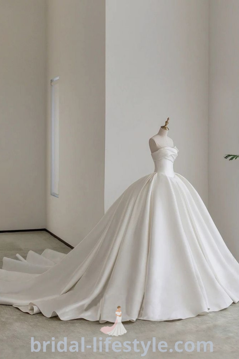 An elegant silk duchess satin wedding dress displayed in an empty room, exemplifying romantic bridal trends for dreamy brides. This stunning strapless ballgown features poofy details, as seen on bridal-lifestyle.com, and is part of the best aesthetic ideas for the special day.