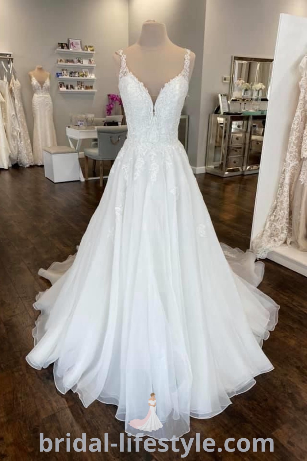 A white A-line wedding dress is showcased in a bridal shop alongside other elegant gowns, offering inspiration for brides seeking dreamy wedding dresses. This display on bridal-lifestyle.com highlights classic styles and trends, perfect for romantic brides aiming for the best aesthetic ideas for their special day.
