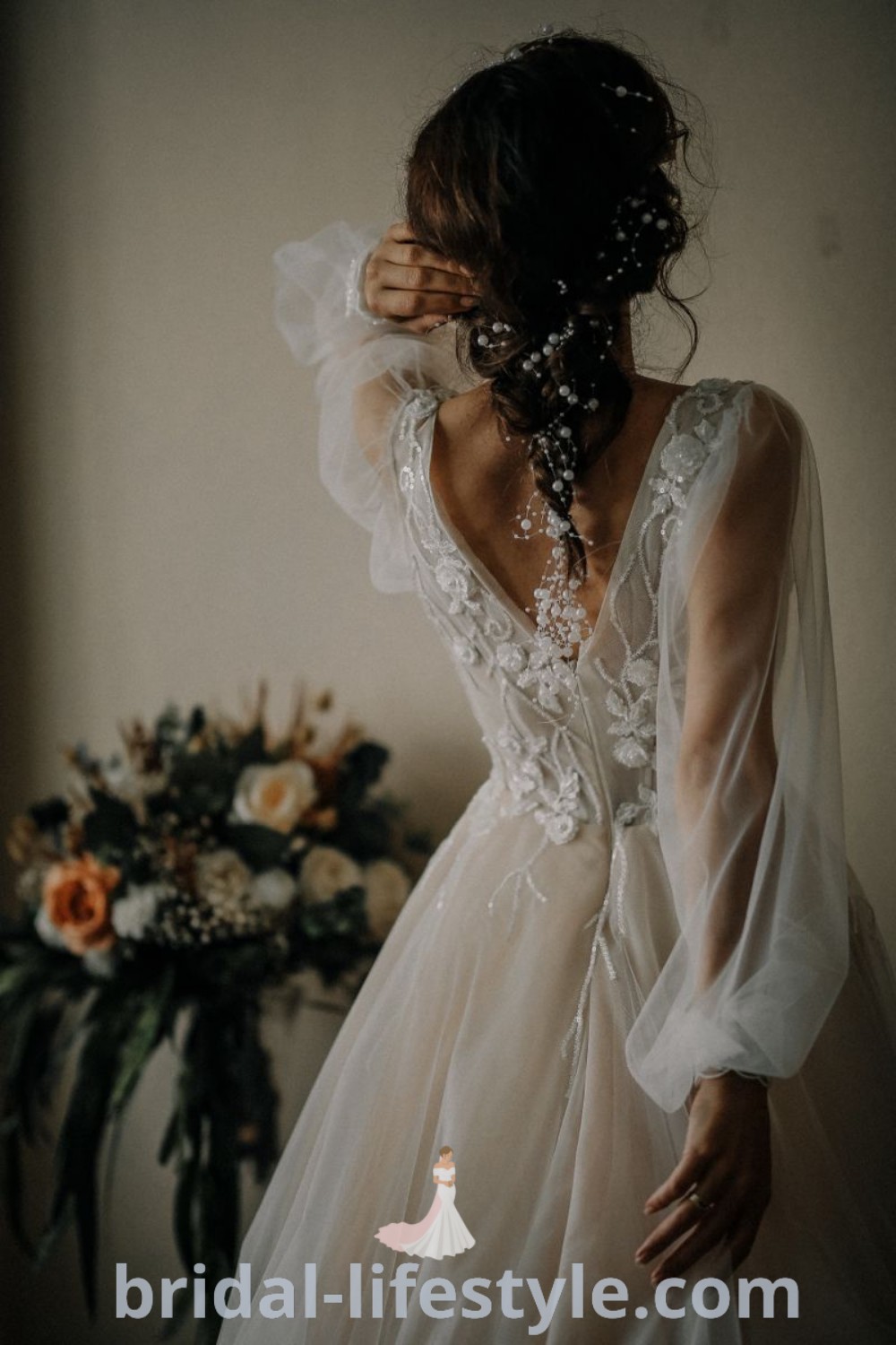 A woman in a wedding dress holding her hair back, showcasing a casual lace wedding dress in boho chic style. This off white wedding dress with sleeves offers a whimsical look, perfect for every bride