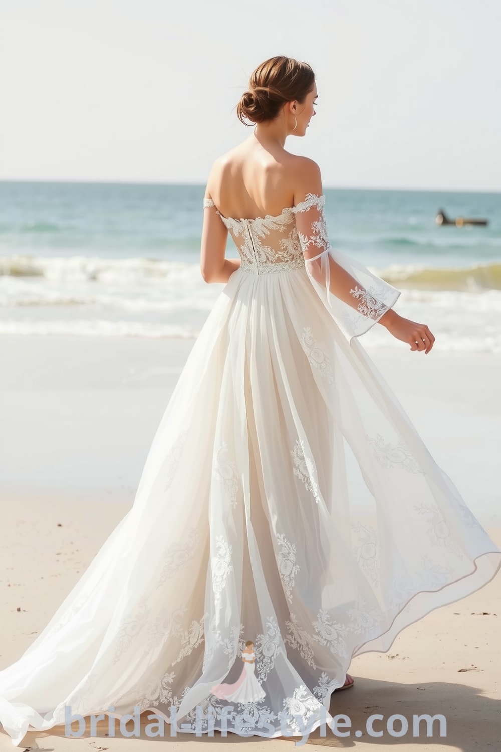 A stunning boho beach wedding dress featuring flowing layers of lace and chiffon, off-the-shoulder sleeves, and floral lace appliqués. bridal-lifestyle.com
