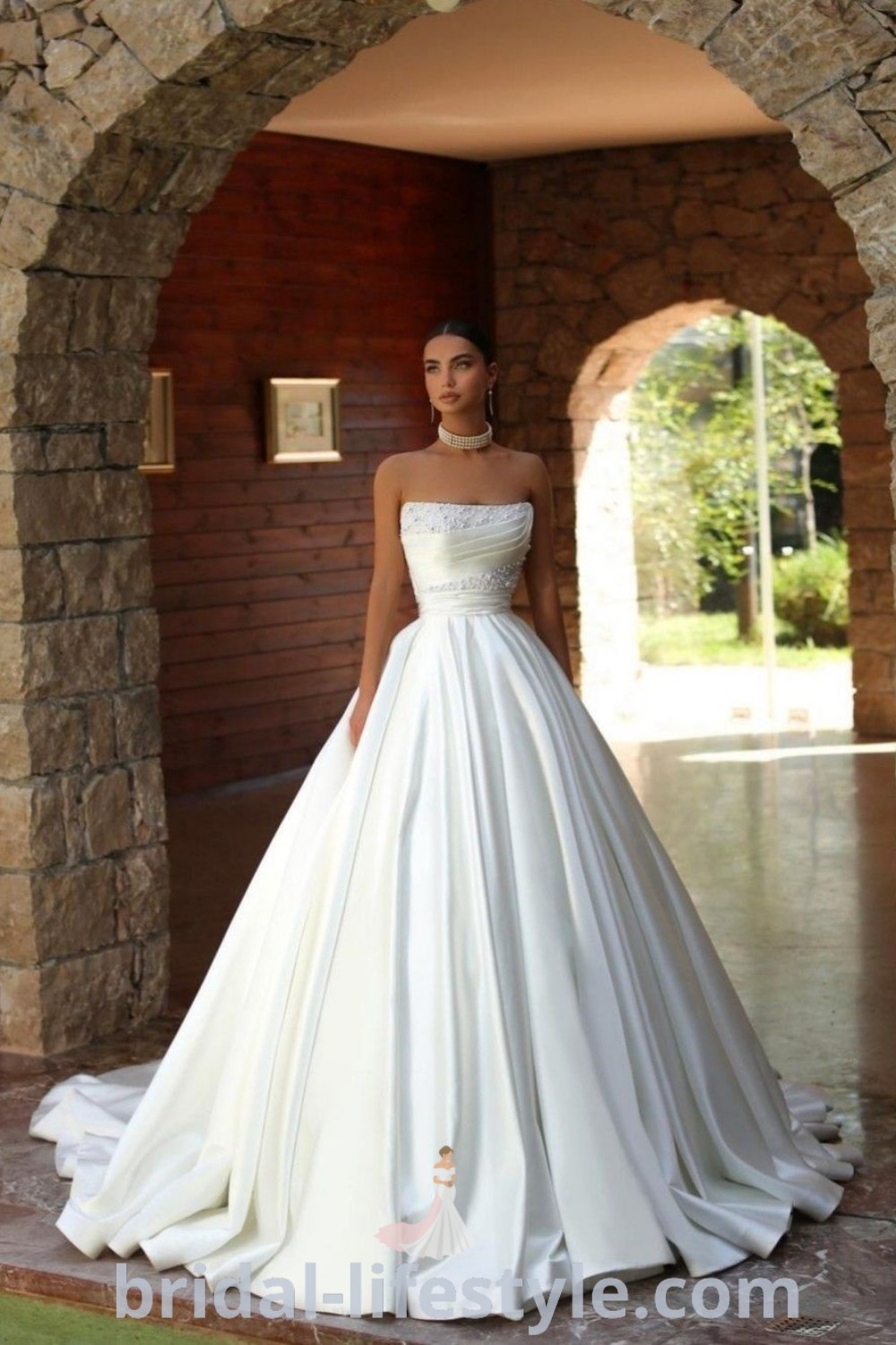 An elegant woman in a white wedding dress poses gracefully, showcasing a ballgown silhouette inspired by Cinderella. This stunning dress represents old money bride style and offers inspiration for brides seeking the best aesthetic ideas for their special day. Discover more on bridal-lifestyle.com.
