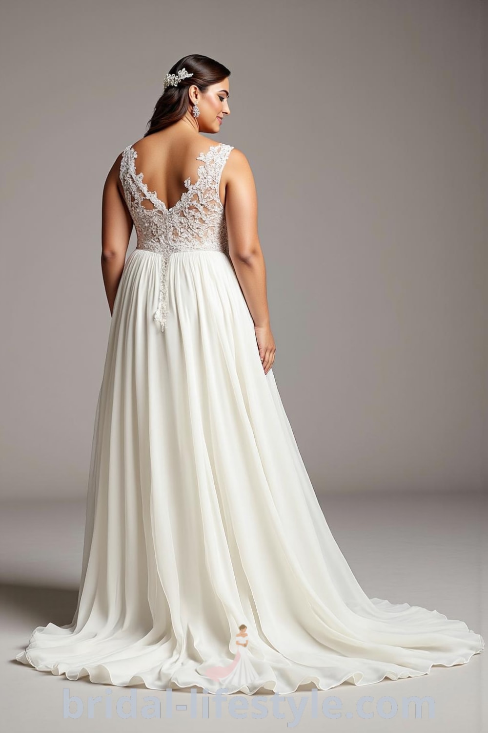 A-line wedding dress for curvy brides featuring a satin bodice with lace appliqués, a flowing chiffon skirt, a deep V-neckline, and elegant lace details with buttons at the back. bridal-lifestyle.com