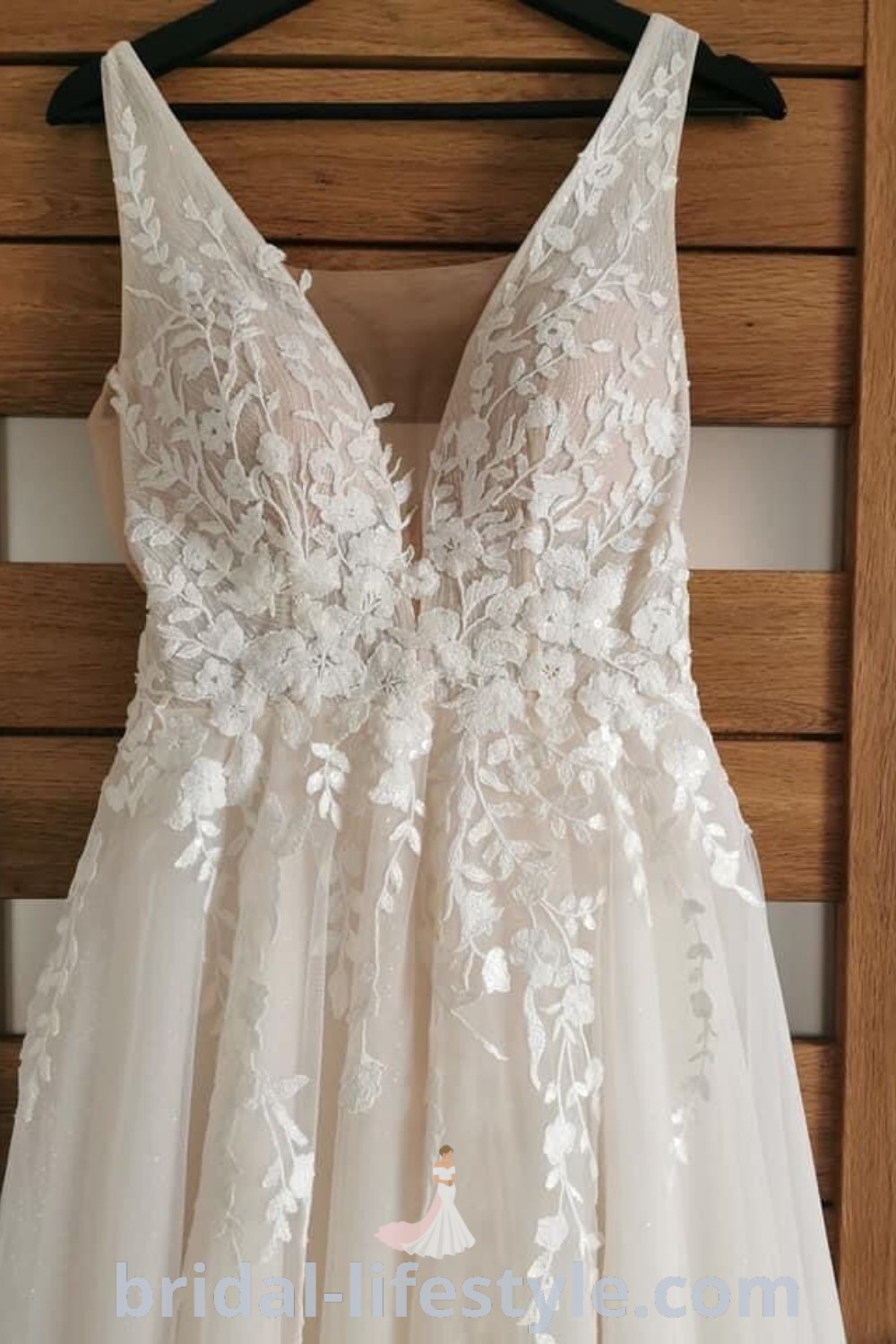 A stunning wide strap wedding dress hanging on a wooden hanger, showcasing an olive green design perfect for dreamy brides looking for elegant inspiration. This handmade gown embodies the best wedding dress trends and aesthetic ideas for the special day. Explore more at bridal-lifestyle.com.