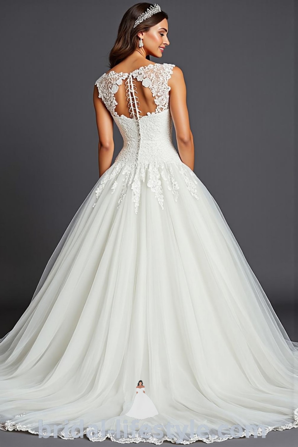 Princess ballgown with a voluminous tulle skirt, intricately adorned lace appliqués on the bodice, and a detailed lace-up back. bridal-lifestyle.com